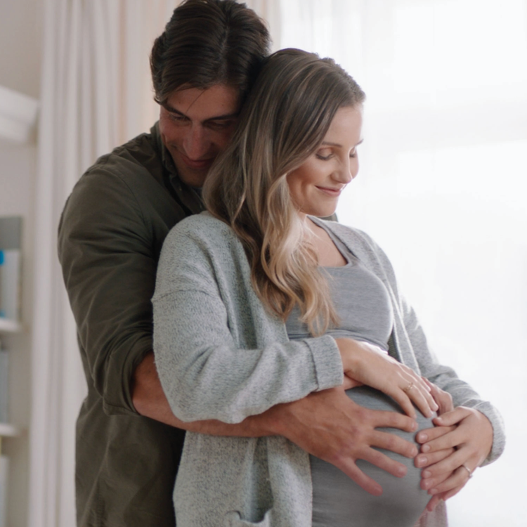 Gravid kvinne og mann i omfavnelse