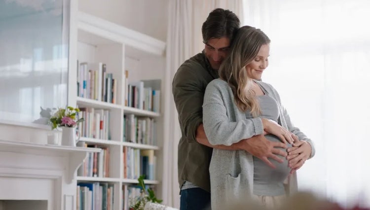 Gravid kvinne og mann i omfavnelse